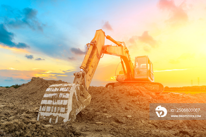 Excavator work on construction site at sunset