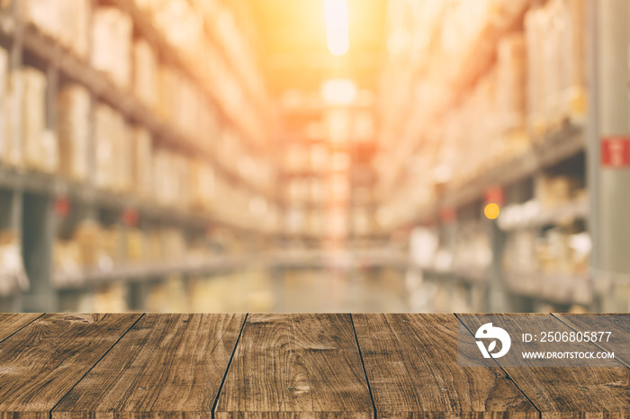 Warehouse inventory in blur for background with empty wooden foreground space.