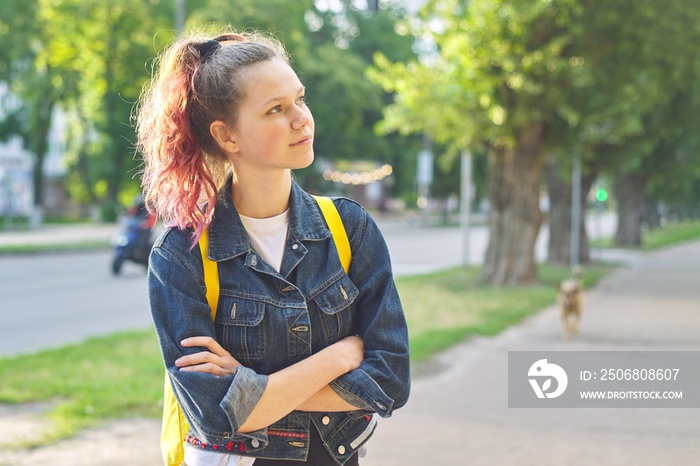 Serious teen schoolgirl with backpack, hands crossed