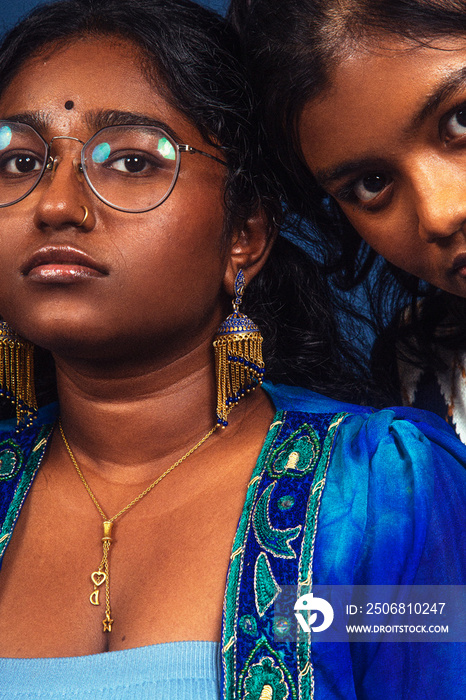 group portraits of dark skinned Indian women from Malaysia against a dark blue background