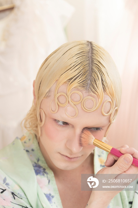 close up beauty of non-binary hispanic person applying makeup