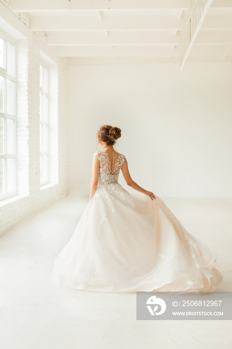 bride in white dress. young woman in wedding dress in white room.