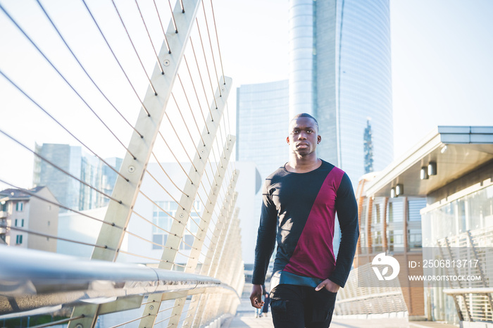 Young man walking across footbridge