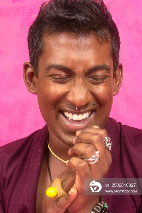 马来西亚印度男子穿着和服在工作室的粉色背景下大笑