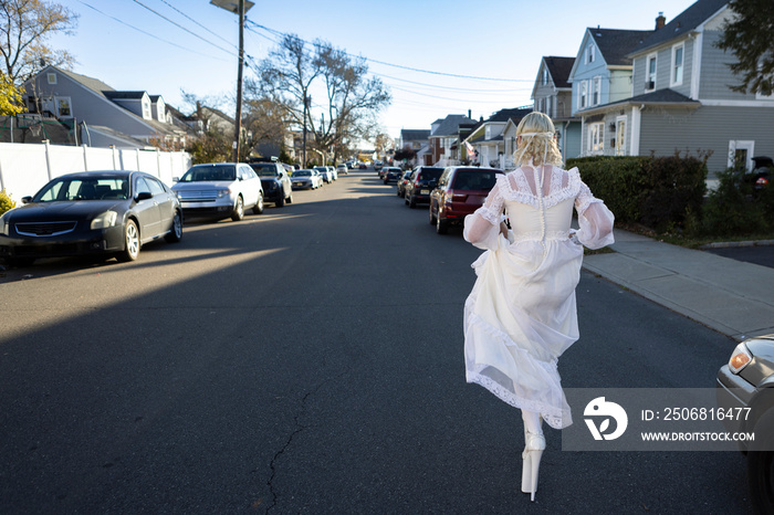 fashion portrait of non-binary person wearing white dress in suburbia