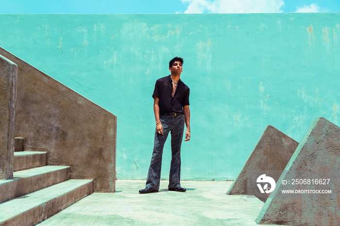 fashion portrait of dark skinned Indian man in concrete surroundings