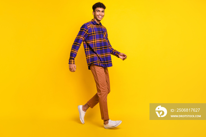 Full size profile photo of positive dark skin person walking toothy smile isolated on yellow color b