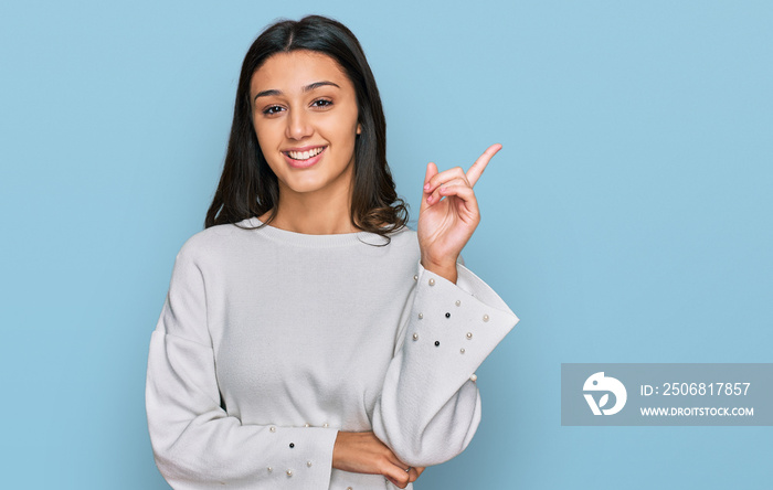 Young hispanic girl wearing casual clothes with a big smile on face, pointing with hand and finger t