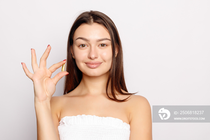 Healthy Diet Nutrition. Beautiful Smiling Young Woman Holding Fish Oil Pill In Hand. Closeup Of Happ