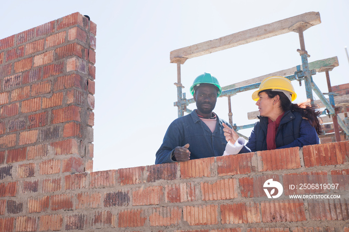 妇女和建筑工人在建筑工地上交谈