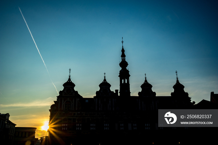 High contrast silhouettes. Sun light diffraction effect. Summer evening street view from Grote Markt