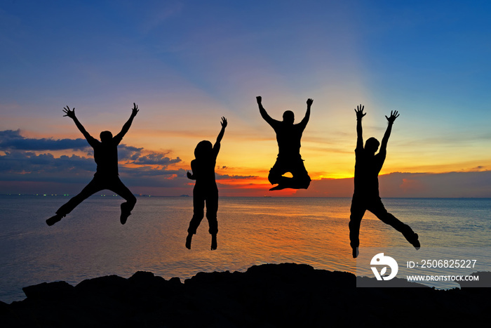 Silhouette of friends and teamwork jumping on beach during sunset time for success business. Lifesty