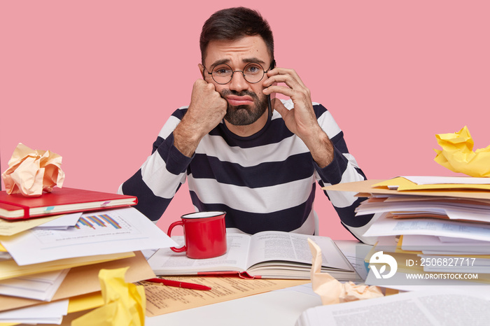 Stressful discontent man has dark stubble, has phone conversation, feels tired of working long time,