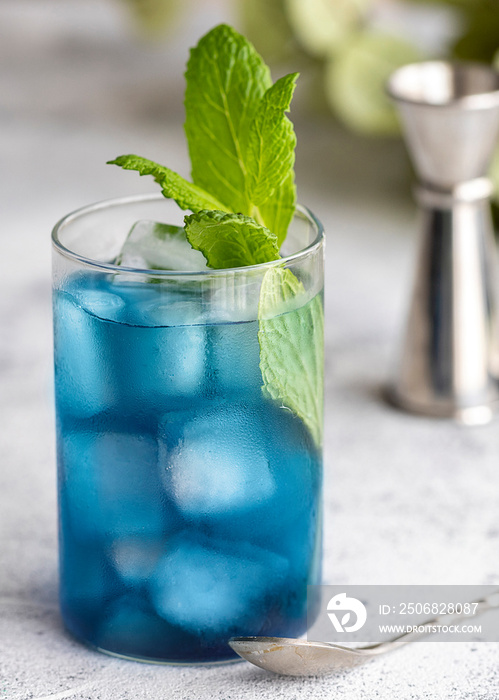 Blue lagoon, Tropical cocktail served with ice cubes decorated with mint. Refreshing alcohol drink f