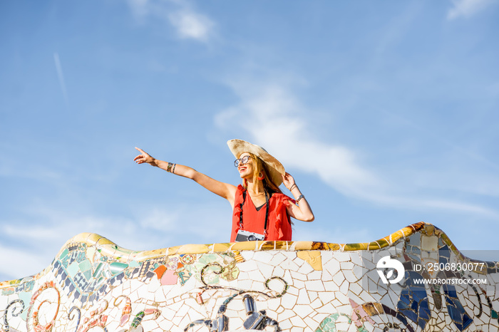 View on the beautiful terrace decorated with mosaic with happy woman tourist in Guell park in Barcel