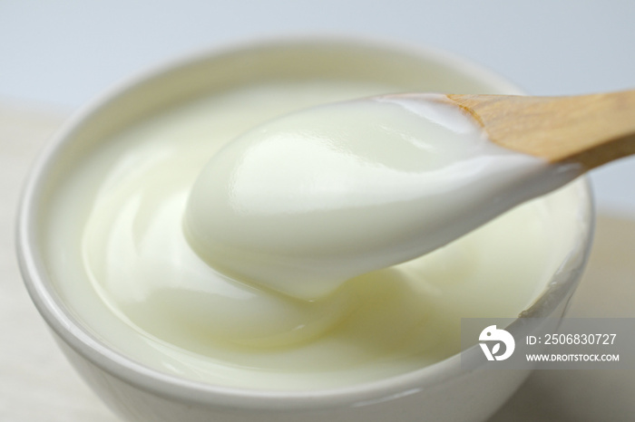 Bowl of sour cream yogurt with wooden spoon