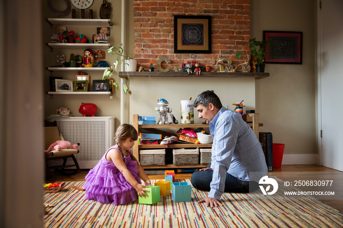 Father playing with daughter in living room