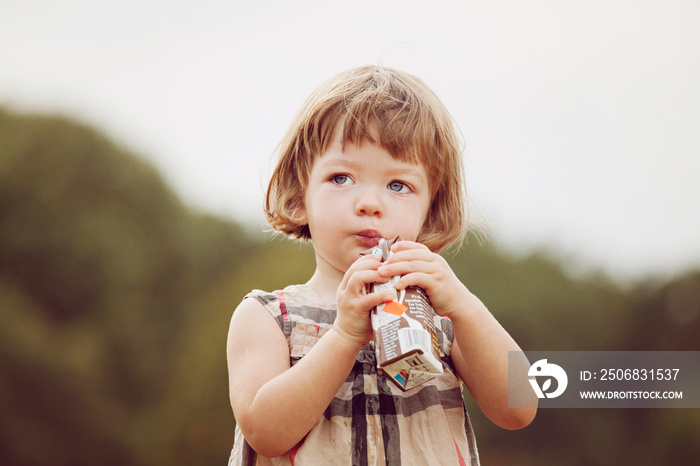 Portrait of girl (2-3) drinking juice in Prospect park