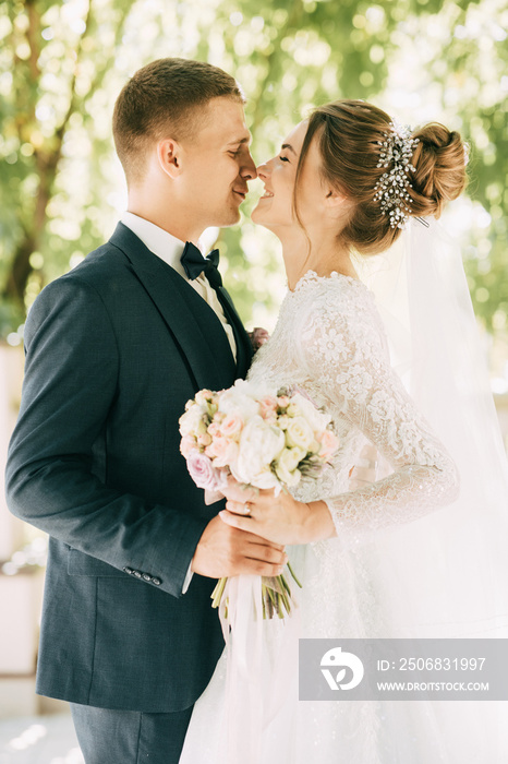 Portrait of the bride and groom with a bouquet of flowers in the park