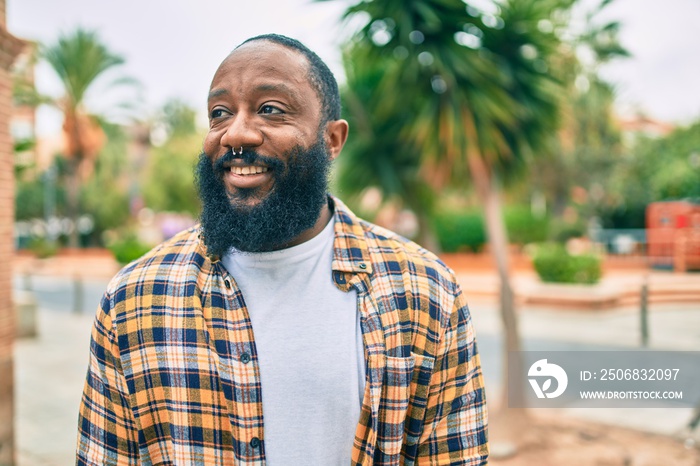 Handsome modern african american man with beard smiling positive standing at the street