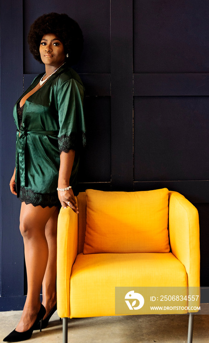 Black woman with afro standing by chair