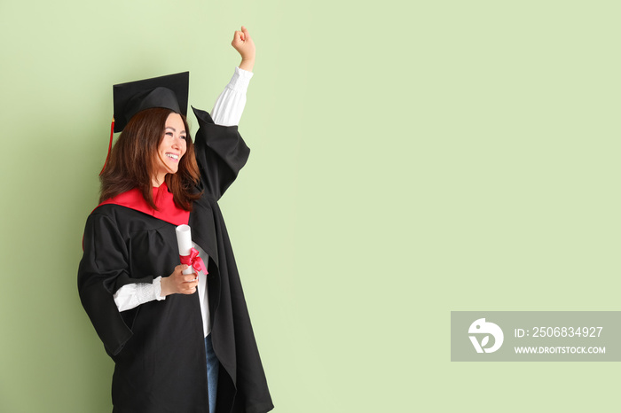 Happy female graduating student with diploma on color background