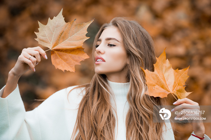 Woman in a autumn park. Lady with a leaf.