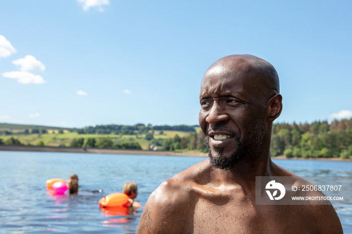 Portrait of smiling man in lake, Yorkshire, UK