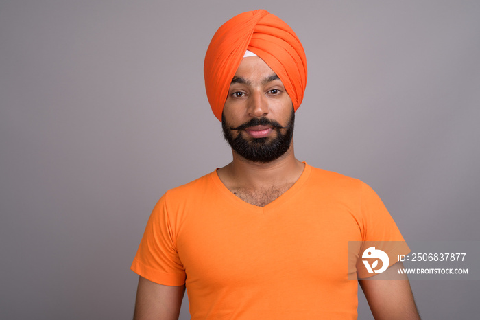 Indian Sikh man wearing turban and orange shirt