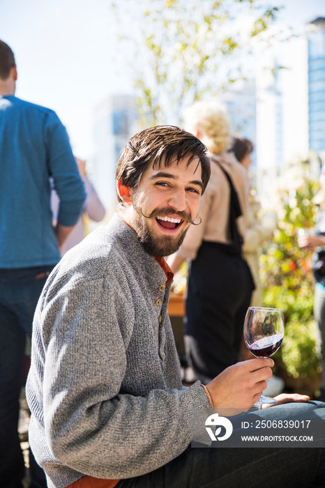 Young man with glass of wine outdoors