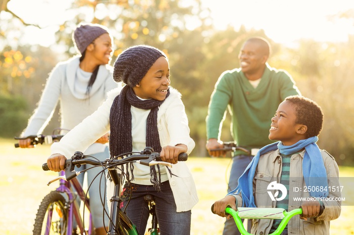 骑自行车的年轻微笑的美国黑人家庭
