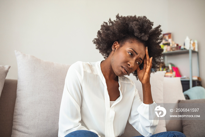 Close up african female sit on couch feels unhappy desperate thinking about personal difficulties me