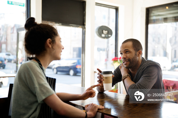 Customer talking with barista in cafe