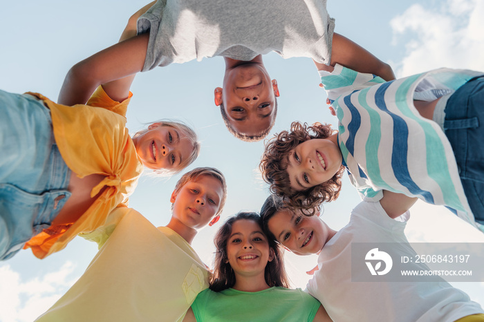 bottom view of positive multicultural children looking at camera