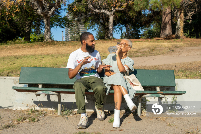 Couple sitting on bench and drinking water