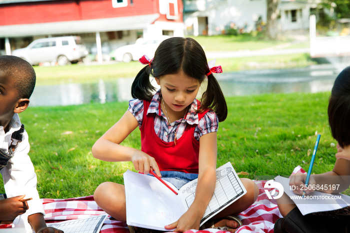 Children (4-5, 8-9) writing on field trip