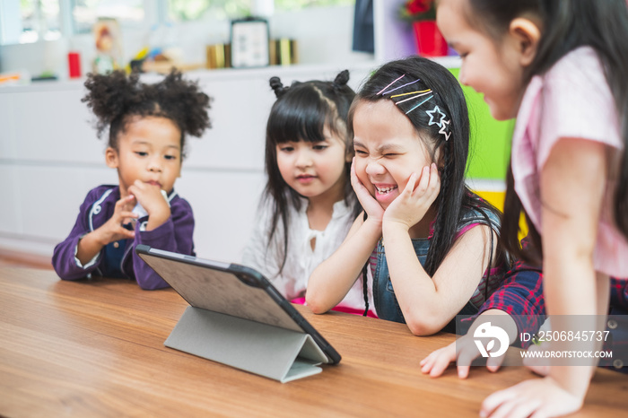 Group of diversity cute kids watching on tablet for lesson in classroom, education concept