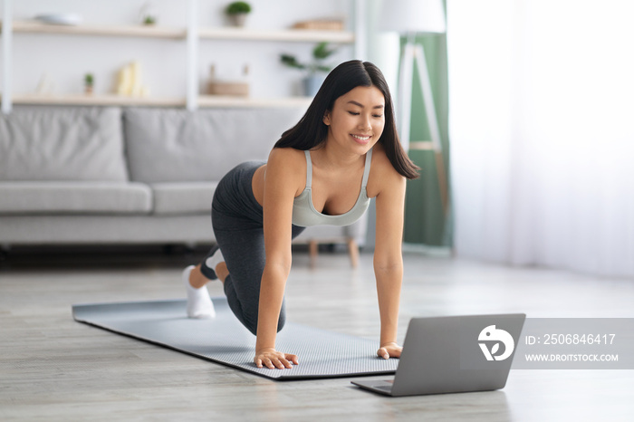 Happy Fit Asian Lady Making Online Sport Trainings At Home With Laptop