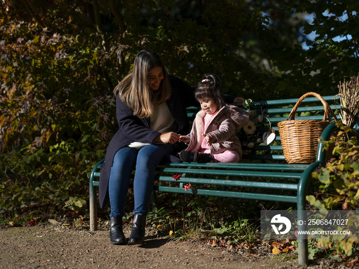 患有唐氏综合症的母亲和女儿坐在长椅上