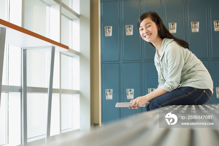 Pretty, Asian student in front of school lockers