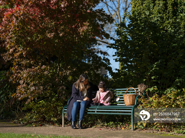 Mother and daughter with Down syndrome sitting on bench