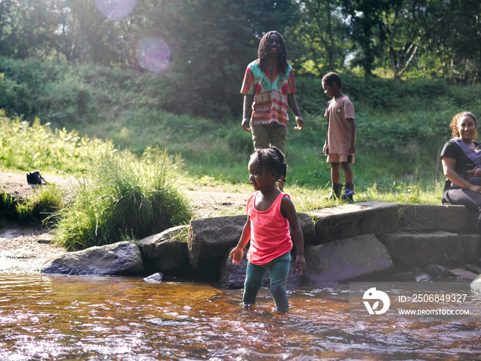 UK, Family playing in shallow creek