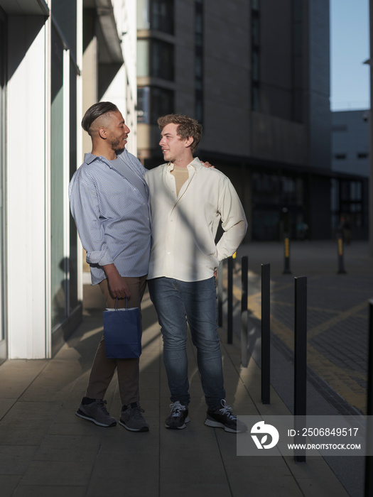 UK, South Yorkshire, Smiling gay couple embracing in city