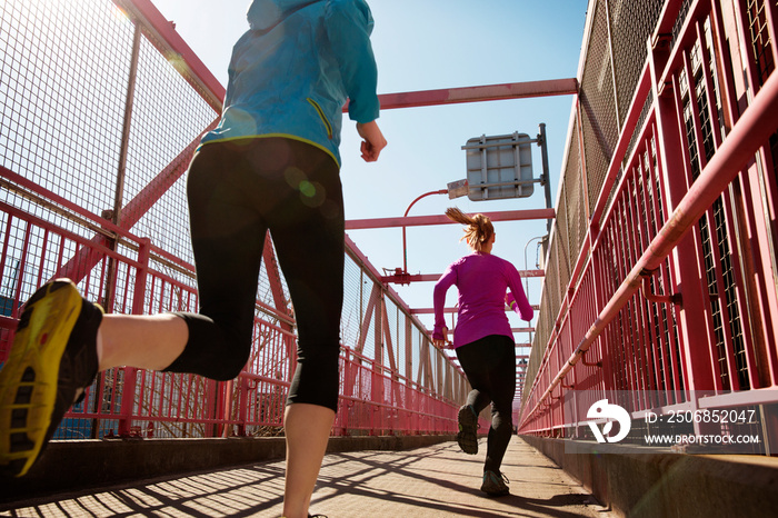 Women jogging along foot bridge