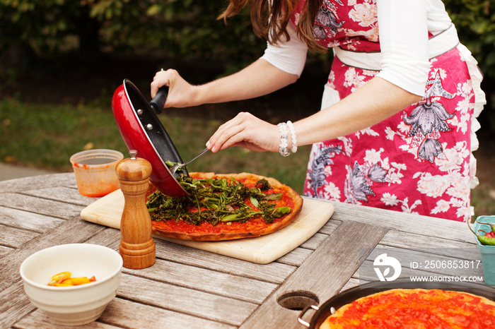 Mid section of woman making pizza outdoor