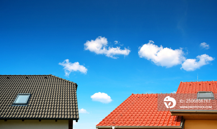 Roof house with tiled roof on blue sky.