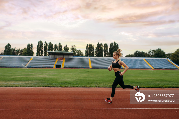 Female runner jogging, training on stadium