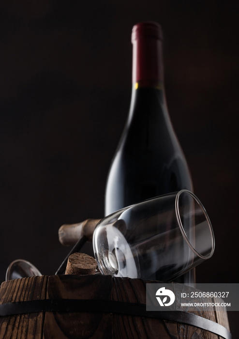 一瓶葡萄酒和空的经典酒杯，木桶顶部有软木塞和老式开瓶器