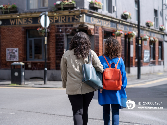 英国，女同性恋情侣走在街上的后视图