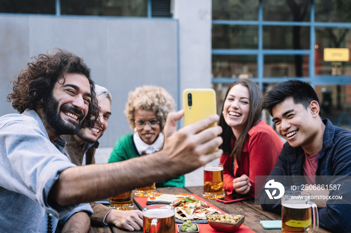 一群快乐的朋友在户外餐厅酒吧自拍，在社交媒体上分享庆祝活动